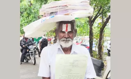 மனு கொடுத்த ஒப்புகை சீட்டை தலையில் சுமந்து வந்த முதியவர்- கலெக்டர் அலுவலகத்தில் பரபரப்பு