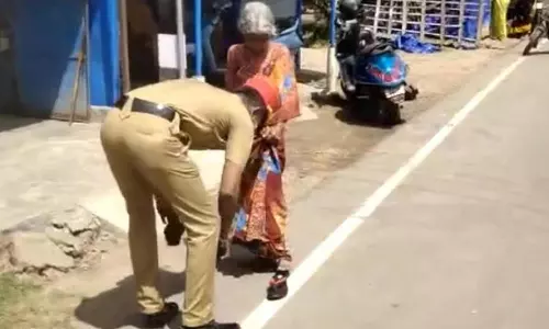 வெயிலில் வாடி வதங்கிய மூதாட்டிக்கு செருப்பு அணிவித்து, குடை கொடுத்து உதவிய போலீஸ்காரர்