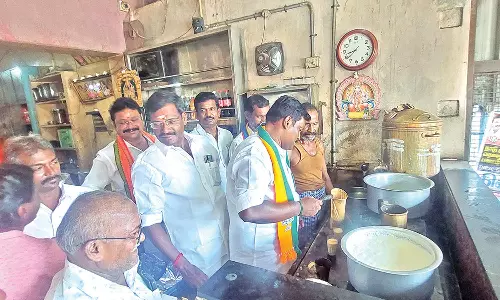 பா.ஜனதா வேட்பாளர் பாலகணபதி டீக்கடையில் டீ போட்டு கொடுத்து ஓட்டு வேட்டை