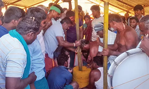 பக்தர்கள் மீது உரல் வைத்து மஞ்சள் இடித்து விநோத வழிபாடு