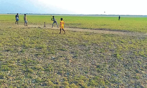 நீரின்றி வறண்டதால் வீராணம் ஏரியில் கிரிக்கெட் விளையாடும் சிறுவர்கள்