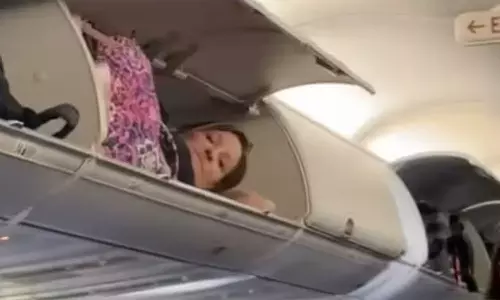 விமானத்தில் லக்கேஜ் வைக்கும் இடத்தில் தூங்கிய பயணி