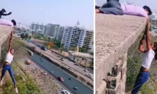 உயரமான கட்டிடத்தில் அந்தரத்தில் தொங்கி ஆபத்தான சாகசம்: இளம்பெண் கைது- வீடியோ