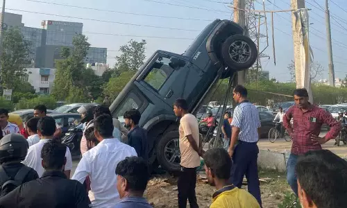 மின்கம்பத்தில் ஏறிய கார் - வைரலாகும் புகைப்படம்