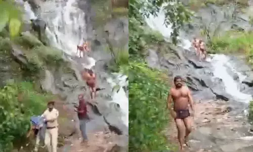 தடையை மீறி அருவியில் குளித்தவர்களின் ஆடைகளை எடுத்துவந்த போலீசார் - வீடியோ
