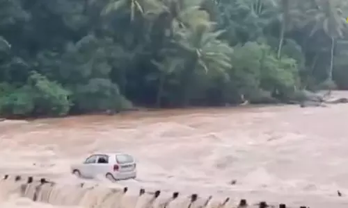 தண்ணீரில் மூழ்கிய பாலம்: கர்ப்பிணி மனைவியை துணிச்சலாக காரில் அழைத்துச்செல்லும் கணவர்- வீடியோ