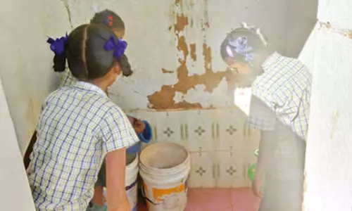 கழிவறையை மாணவிகள் சுத்தம் செய்வது போன்று பரவும் காட்சி.