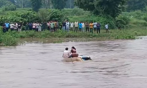 ஆற்றில் அடித்துச்செல்லப்பட்ட காரின் மேற்கூரையில் 2 மணி நேரம் சிக்கித்தவித்த தம்பதி