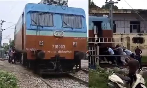 Railway department employees pushing the train engine in Uttar Pradeshs Bijnor