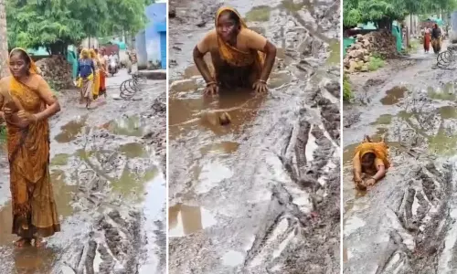 Woman crouched down in mud demanding road repair in MP