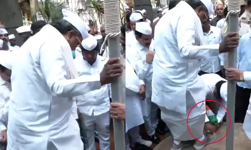 கையில் தேசிய கொடியுடன் ஷூவை கழற்றிவிட்ட உதவியாளர்.. புது சர்ச்சையில் சித்தராமையா - வீடியோ