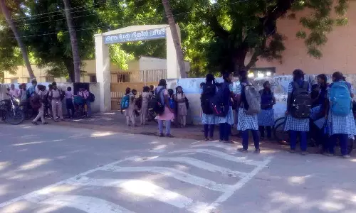 பள்ளிக்கு பூட்டுப்போடப்பட்டதால் 1 மணி நேரம் வெளியே தவித்த மாணவ, மாணவிகள்