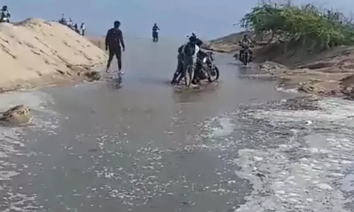 கடல் நீர் வெளியேறியதால் பழவேற்காடு- காட்டுப்பள்ளி சாலை மணலால் மூடியது