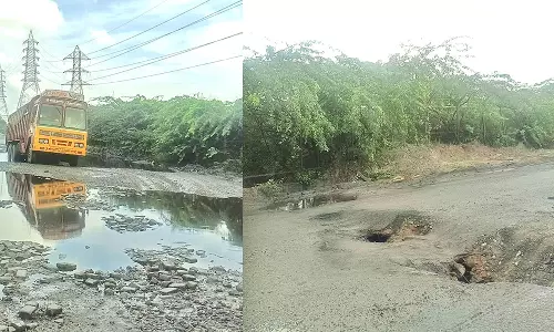 காட்டுப்பள்ளியில் சாலையில் ராட்சத பள்ளங்களால் 50 லாரிகள் பழுதானது