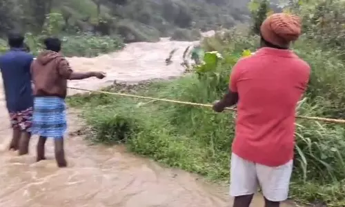 கனமழை- வெள்ளப்பெருக்கால் கயிறு கட்டி ஆற்றை கடக்கும் கிராம மக்கள்