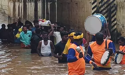 சுரங்கப்பாதையில் மழை வெள்ளம்- இடுப்பளவு தண்ணீரில் இறந்தவர் உடலை தூக்கி சென்ற உறவினர்கள்