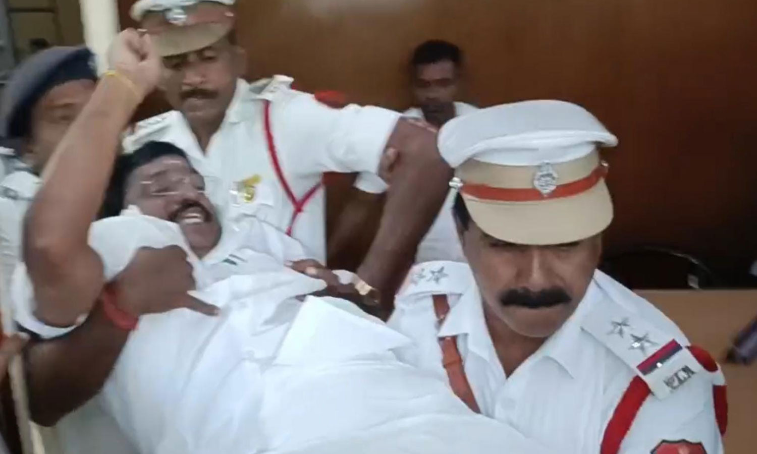 புதுச்சேரி சட்டசபையில் தி.மு.க.-காங், எம்.எல்.ஏ.க்கள் தர்ணா: குண்டுகட்டாக தூக்கிச்சென்று வெளியேற்றம்